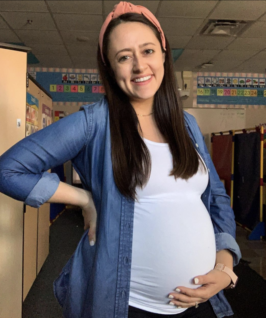 image featuring pregnant teacher holding her belly smiling